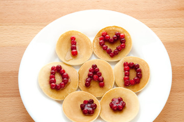 Wall Mural - Pancakes with cranberries and syrup on a wooden background. Father's Day. Breakfast.