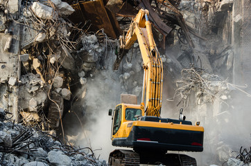 Excavator working at the demolition of an old industrial buildin