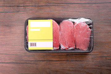 Poster - Packed pieces of beef meat on wooden background