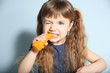 © Africa Studio - Little girl with carrot on wall background