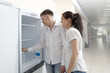 © Andrey Burmakin - Happy family couple looking at large fridges in store