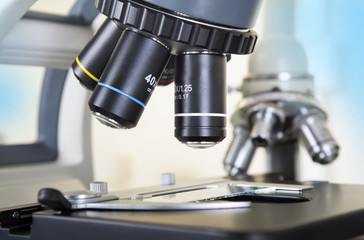 Professional microscope close-up with chemist scientific researcher hands using microscope in the laboratory interior.