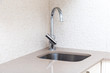 Kitchen stone counter with undermount build-in sink and mixer in a beige colors environment