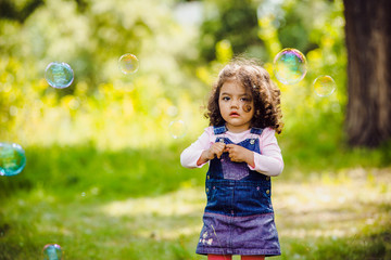 Portrait of cute girl blowing soap bubbles