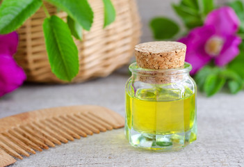 Small  bottle of natural cosmetic (massage) oil and wooden hair comb