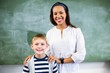 © WavebreakMediaMicro - Portrait of smiling teacher and schoolboy standing in classroom