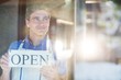 © WavebreakMediaMicro - Smiling chef holding open sign