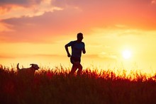 Athletic Runner With Dog At The Sunset