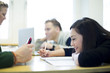 © Maskot - University students studying at table in common room