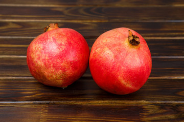 Two whole pomegranate on wooden Board