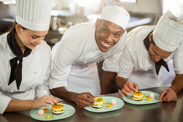 Wall Mural - Chefs team finishing dessert plates