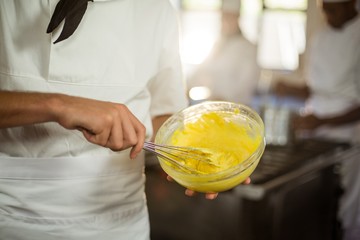 Wall Mural - Mid section of chef mixing dough