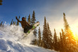 Jumping snowboarder on snowboard in mountains in ski resort