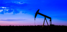 Silhouette Of Oil Pumps At Oil Field With Sunset Sky Background