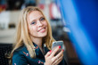 © romankosolapov - Girl texting on the smart phone in a restaurant terrace with an unfocused background