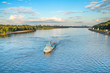 Tourist boat on the Dnepr River in Kiev, Ukraine, bridges and city skyline in background