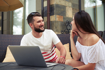 Canvas Print - Smiling couple on couch is chatting on terrace in the yard