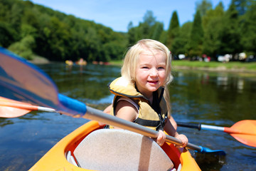 Family kayaking on the river on sunny summer day. Happy little child having fun enjoying adventurous experience. Water sport activities day during summer vacation