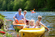 Family kayaking on the river. Active father with children, two teenage boys and little girl, having fun together enjoying adventurous experience with kayak on a sunny day during summer vacation
