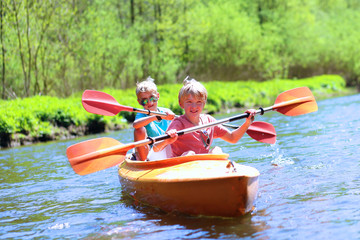 two boys kayaking on the river. active happy friends, teenage schoolboys, having fun together enjoyi