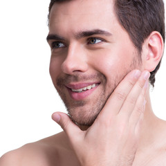 Wall Mural - Smiling young man with hand near the face.