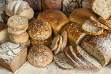 Bułki, kromki chleba i całe chleby pełnoziarniste, obsypane mąką - piekarnia