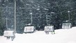Skiers On Chairlift With Snow Falling