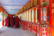 Buddhist nun walking touch a prayer wheels around the sanctuary at Larung gar (Buddhist Academy) in Sichuan, China