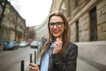 Businesswoman walking down the street while talking on smart pho