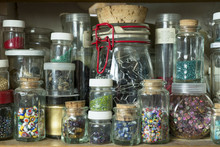 Jars Of Buttons And Beads On Wooden Shelf