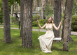 © rubchikova - Beautiful girl in a long dress on a swing. Portrait of a smiling girl in full growth. Young woman on a swing