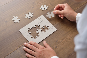 Wall Mural - Image of businesswoman connecting elements of white puzzle