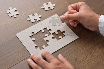 Wall Mural - Folding puzzle hand parts on a wooden table