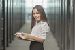 © jaengpeng - Happy young business woman with a folder at office building
