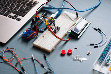 Engineer background with microcontroller and different details on black table. Engineer workplace, prepared for upgrading laptop. Microcontroller with necessary for programming work details