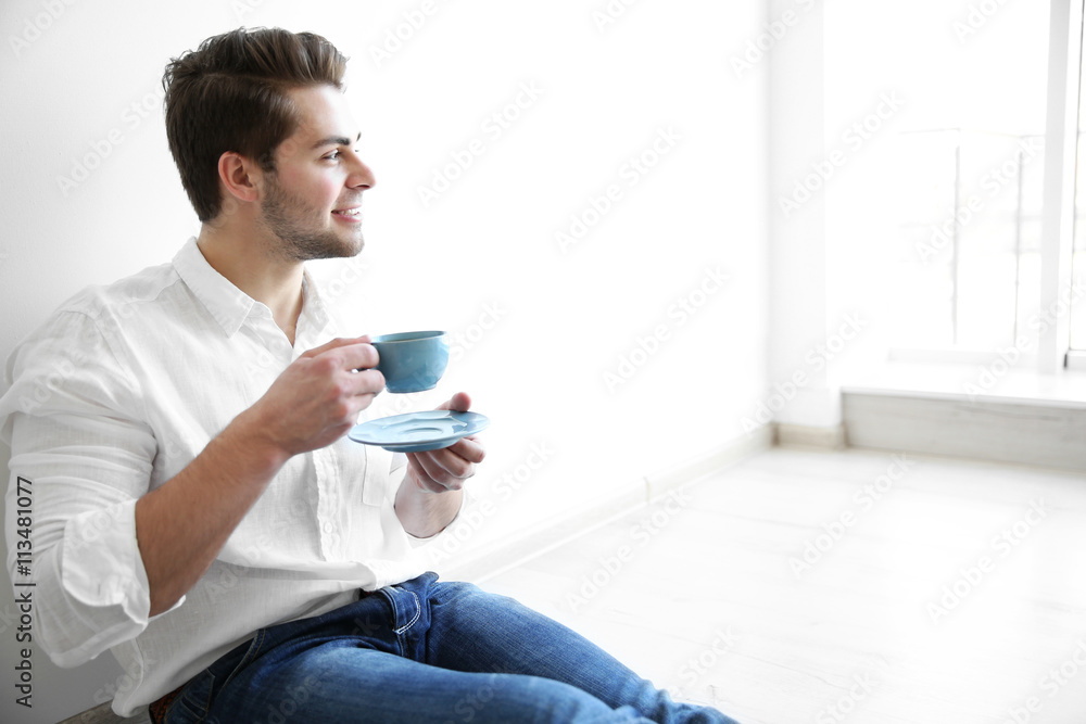 Handsome man drinking coffee in the room