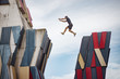 © Cavan Images - Man jumping over a gap between two buildings
