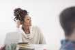 © Cavan Images - Smiling businesswoman sitting by table in office