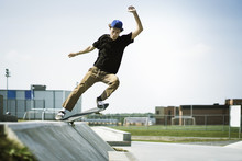 Young Man Performing Stunts On Skateboard