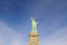 Low Angle View Of Statue Of Liberty Against Blue Sky