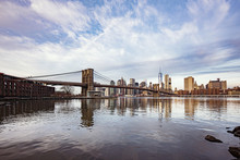 View Of Brooklyn Bridge And Manhattan Skyline Against Cloudy Sky