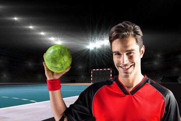 Wall Mural - Portrait of happy athlete man holding a ball  against handball field indoor 