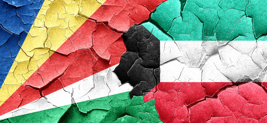 seychelles flag with Kuwait flag on a grunge cracked wall