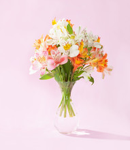 Bouquet Of Alstroemeria In A Transparent Glass Vase On Pink Background
