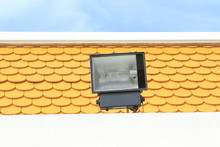 Halogen, Metal Halide Floodlight Lamp Installed On Roof Top With Yellow Scale Background