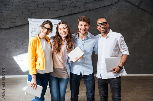 Fotografía Multiethnic group of happy young business people standing in office