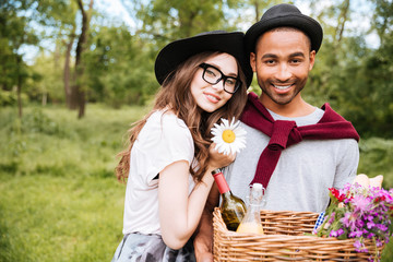 Poster - Happy young couple with basket of drinks, food and flowers