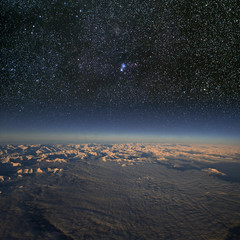 Wall Mural - high altitude view of snowy mountains and cloud with stars above.
