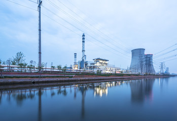 modern power station near river at twilight