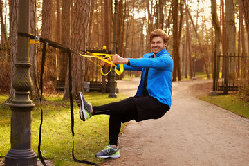 Wall Mural - Sporty male exercising with fitness trx.